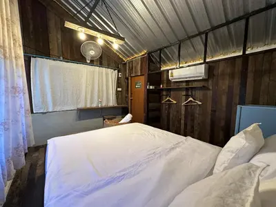 a bedroom with a large white bed in it at Cashew Garden House in Chalong