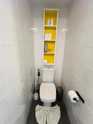 a bathroom with a white toilet with a shelf at Loft condo in Phuket