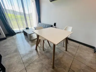 a white table and chairs in a room with a window at Loft condo in Phuket