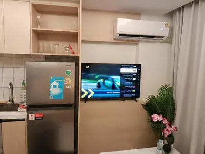 a kitchen with a refrigerator and a tv on a wall at Super 1Bdr Fantasea, Kamala Beach Roof Pol Wi Fi in Kamala Beach