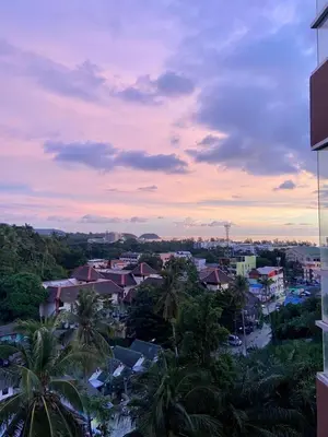 a view of a city at sunset with palm trees at Sea view studio Chic Condo Karon in Karon Beach