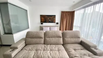 a living room with a couch and a large window at Sea view studio Chic Condo Karon in Karon Beach