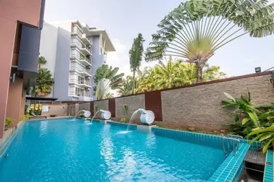 a pool at a hotel with palm trees at Sea view studio Chic Condo Karon in Karon Beach