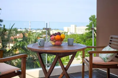 a table with a bowl of fruit on a balcony at Sea view studio Chic Condo Karon in Karon Beach