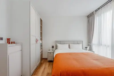 a white bedroom with a bed with an orange blanket at Квартира в The Title Halo 1 in Nai Yang Beach
