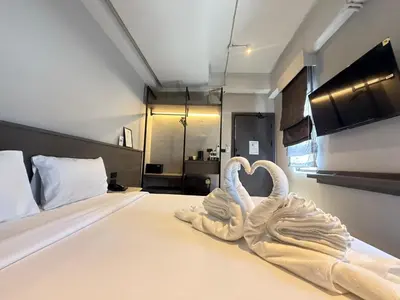 a bedroom with a bed with two swans shaped towels at Leon's Loft House in Patong Beach