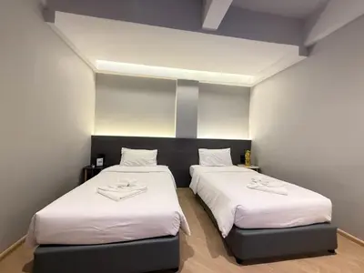 two beds in a small room with white sheets at Leon's Loft House in Patong Beach