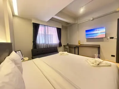 a bedroom with a large bed with a tv on the wall at Leon's Loft House in Patong Beach