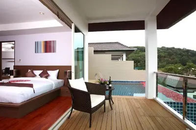 a bedroom with a bed and a balcony with a pool at Bangtao Tropical Residence Resort and Spa in Surin Beach