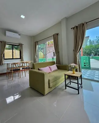 a living room with a green couch and a table at Aonang Riverside Home in Ban Khlong Son