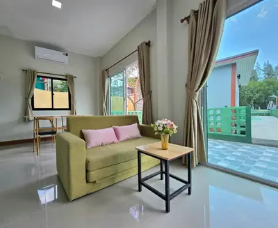 a living room with a couch and a table at Aonang Riverside Home in Ban Khlong Son