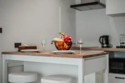 a kitchen island with two wine glasses and a bowl of fruit at Квартира в The Title Halo 1 in Nai Yang Beach