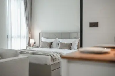 a bedroom with a large bed with white sheets and pillows at Квартира в The Title Halo 1 in Nai Yang Beach