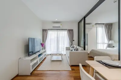 a white living room with a bed and a tv at Квартира в The Title Halo 1 in Nai Yang Beach