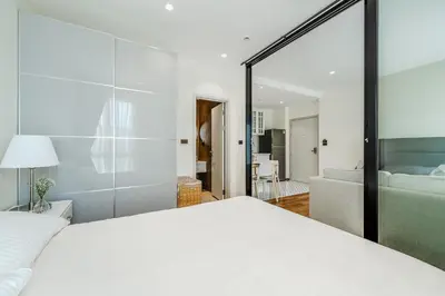 a bedroom with a white bed and a living room at Квартира в The Title Halo 1 in Nai Yang Beach