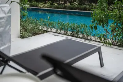 a table and chair next to a swimming pool at Квартира в The Title Halo 1 in Nai Yang Beach