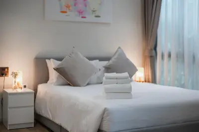 a white bed with white pillows and a window at Квартира в The Title Halo 1 in Nai Yang Beach