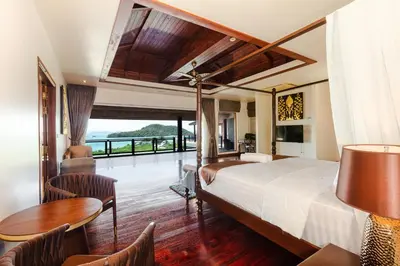 a bedroom with a bed and a table and chairs at Grand View Panwa Luxury Villa in Ban Ao Makham