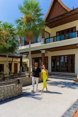 a man and a woman walking in front of a house at Grand View Panwa Luxury Villa in Ban Ao Makham