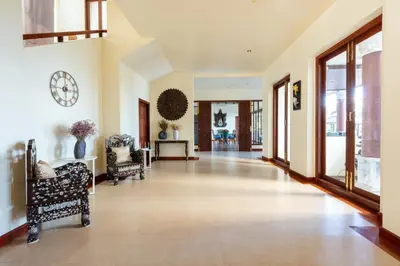 a large hallway with chairs and a clock on the wall at Grand View Panwa Luxury Villa in Ban Ao Makham