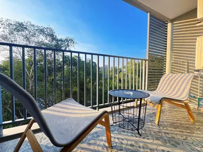 a balcony with two chairs and a table at Digital Nomad Home Away With Pool & Gym in Nai Yang Beach