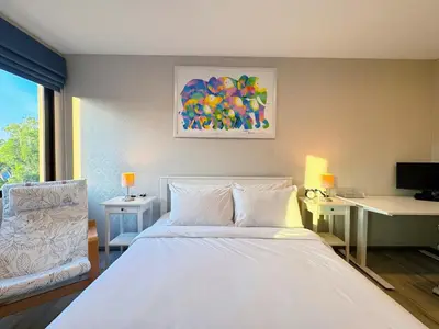 a bedroom with a large white bed and a desk at Digital Nomad Home Away With Pool & Gym in Nai Yang Beach