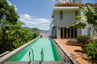 a swimming pool in front of a house at Jirana Patong in Patong Beach