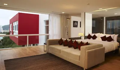 a bedroom with a bed and a couch and a large window at Jirana Patong in Patong Beach
