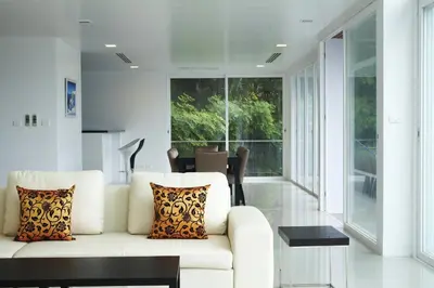 a living room with a white couch and a window at Jirana Patong in Patong Beach