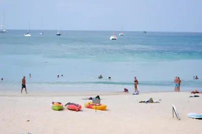 a group of people on a beach with the water at CHEZ MAURICE A RAWAIi in Rawai Beach
