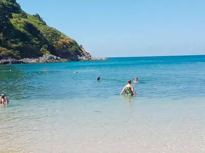 a man standing in the water at the beach at CHEZ MAURICE A RAWAIi in Rawai Beach