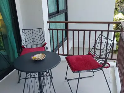 two chairs and a table on a balcony at CHEZ MAURICE A RAWAIi in Rawai Beach