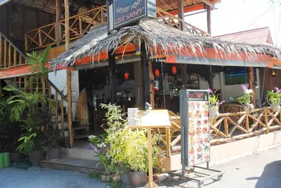 a restaurant with a sign in front of a building at CHEZ MAURICE A RAWAIi in Rawai Beach