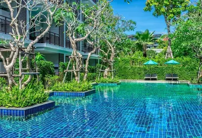 a swimming pool at a resort with trees at CHEZ MAURICE A RAWAIi in Rawai Beach
