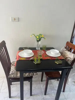 a black table with plates and a vase of flowers on it at Family place in Ban Saiyuan (1)