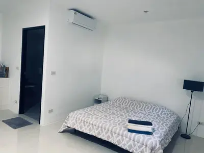 a white room with a bed with towels on it at Гостевой домик in Ban Saiyuan (1)