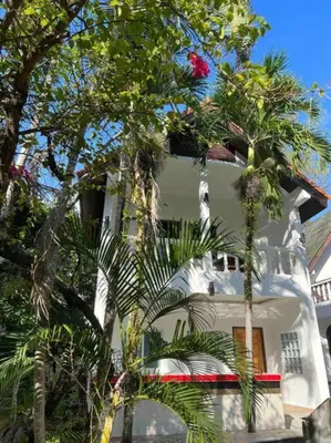 a white building with palm trees in front of it at Charming Villa Suite with Cozy Terrace near Beach in Patong Beach