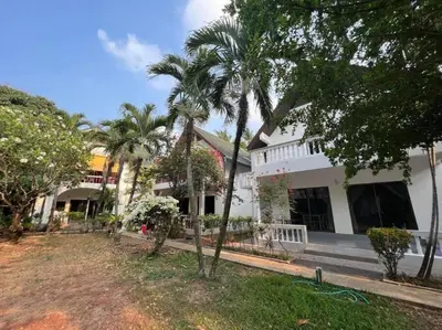 a building with palm trees in front of it at Charming Villa Suite with Cozy Terrace near Beach in Patong Beach