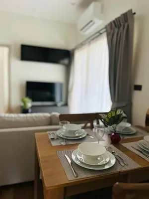 a dining room table with plates and glasses on it at Title Halo, 2 bedrooms apartment in Nai Yang Beach