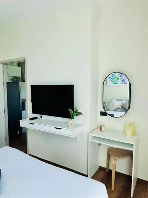 a white bedroom with a tv and a mirror at Title Halo, 2 bedrooms apartment in Nai Yang Beach