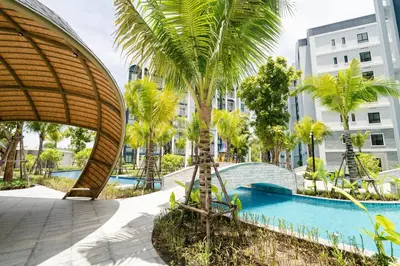 a resort with a swimming pool and palm trees at Title Halo, 2 bedrooms apartment in Nai Yang Beach