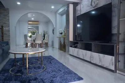 a living room with a large television and a table at MODERN 3BR Katabeach sweet Home in Kata Beach