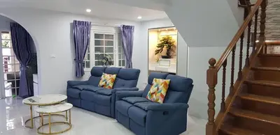 a living room with two blue couches and a staircase at MODERN 3BR Katabeach sweet Home in Kata Beach