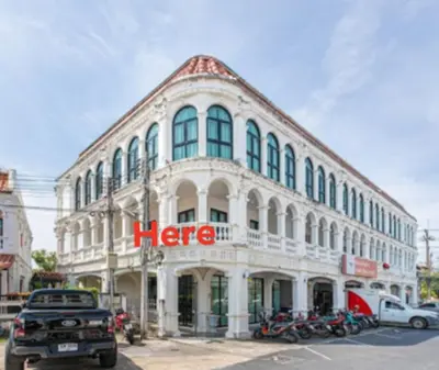 a large white building with a hero sign on it at Home in Phuket in Ban Phlu Yai