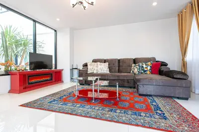 a living room with a couch and a tv at Home in Phuket in Ban Phlu Yai