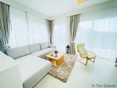 a living room with a white couch and a chair at Anchan House KML Welcome in Kamala Beach