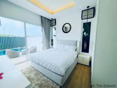 a white bedroom with a bed and a large window at Anchan House KML Welcome in Kamala Beach