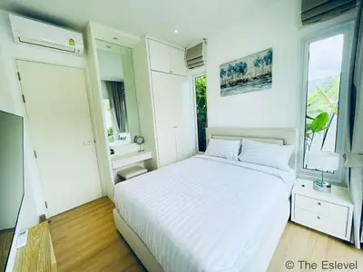 a white bedroom with a bed and a window at Anchan House KML Welcome in Kamala Beach