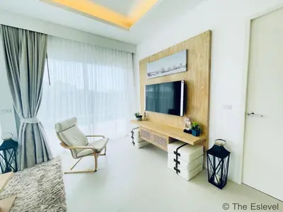 a living room with a television and a chair at Anchan House KML Welcome in Kamala Beach