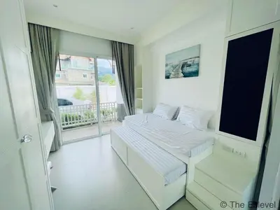 a white room with two beds and a balcony at Anchan House KML Welcome in Kamala Beach